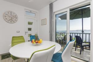 una sala da pranzo con tavolo, sedie e orologio di Apartments with a parking space Brela, Makarska - 11687 a Brela