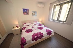 a bedroom with a bed with pink flowers on it at Apartments with a parking space Orebic, Peljesac - 10097 in Orebić