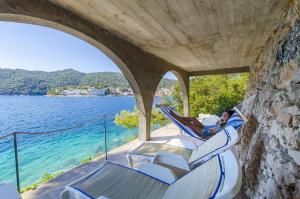 a person sitting in chairs on a house by the water at Apartments by the sea Brna, Korcula - 13492 in Smokvica
