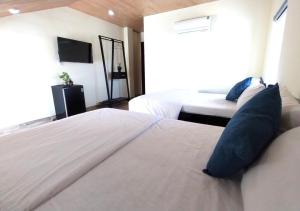 ein Hotelzimmer mit 2 Betten und einem TV in der Unterkunft Giao Hòa Homestay Hội An in Hoi An