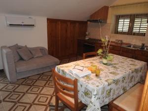 a kitchen and living room with a table and a couch at Apartments by the sea Brna, Korcula - 13492 in Smokvica