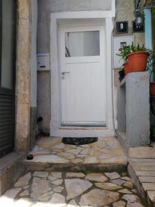 a white door on a building with a potted plant at Apartments by the sea Cres - 13510 in Cres