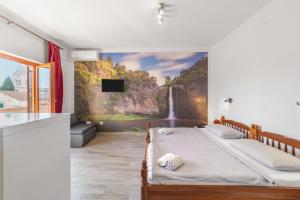 una camera da letto con un murale a cascata sul muro di Apartments and rooms by the sea Sumartin, Brac - 13285 a Sumartin