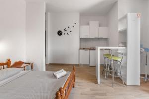Apartments and rooms by the sea Sumartin, Brac - 13285 في سومارتين: غرفة نوم بيضاء مع سرير ومطبخ