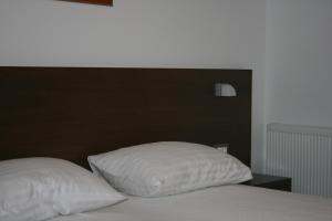 a bed with a black headboard and two white pillows at Apartments by the sea Punat, Krk - 13538 in Punat