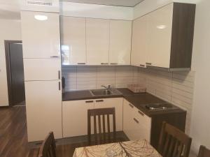 a kitchen with white cabinets and a table and a sink at Apartments by the sea Punat, Krk - 13538 in Punat