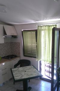 eine kleine Küche mit einem Tisch und einem Fenster in der Unterkunft Seaside holiday house Zatoglav, Rogoznica - 13540 in Rogoznica