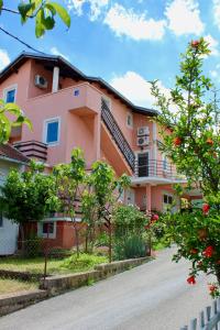 um edifício rosa com árvores em frente a uma rua em Apartments with a parking space Bilice, Krka - 13545 em Sibenik