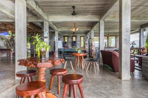 un ristorante con sgabelli e tavoli in legno in una stanza di Deishaview Jungle Hostel a Ko Tao