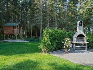 um jardim com parque infantil, um banco e uma casa em A detached holiday home in a highly scenic area em Trierscheid