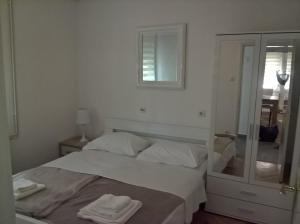 a bedroom with a bed with two towels on it at Apartments with a parking space Kostrena, Rijeka - 13563 in Kostrena