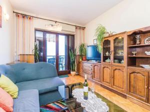 a living room with a blue couch and a tv at Apartments with a parking space Kastav, Opatija - 13568 in Kastav