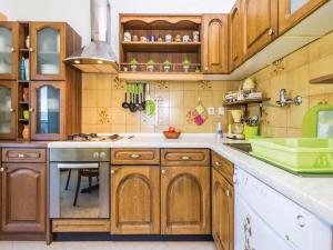 a kitchen with wooden cabinets and a sink at Apartments with a parking space Kastav, Opatija - 13568 in Kastav