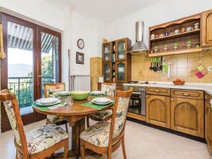 a kitchen with a wooden table and chairs and a kitchen with a window at Apartments with a parking space Kastav, Opatija - 13568 in Kastav +11 photos