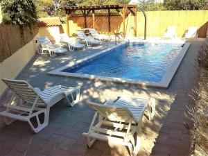 a group of chairs and a swimming pool at Family friendly apartments with a swimming pool Vir - Lozice, Vir - 13569 in Vir