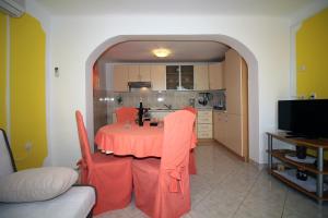 une cuisine avec une table et un chiffon rouge dans l'établissement Apartments by the sea Tisno, Murter - 13588, à Tisno