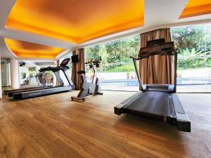 a gym with two treadmills and two exercise bikes at The Palace Hotel Kota Kinabalu in Kota Kinabalu