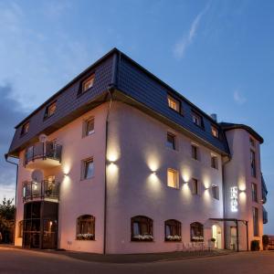 a large white building with a black roof at Amber Hotel in Gdańsk