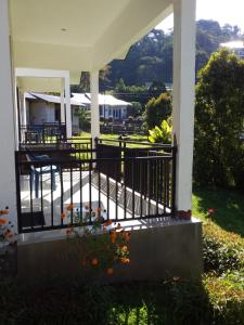 een veranda van een huis met een hek en bloemen bij SHILA GUEST HOUSE in Kelimutu