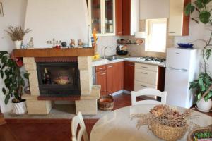 a kitchen with a fireplace in the middle of a table at Secluded fisherman's cottage Cove Smokvina, Hvar - 13608 in Bogomolje