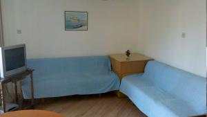 a living room with two blue couches and a television at Apartments by the sea Brna, Korcula - 13618 in Smokvica