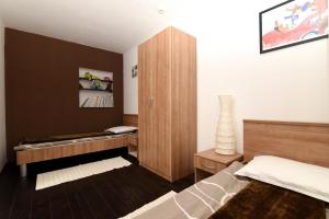 a bedroom with a bed and a wooden cabinet at Apartments with a swimming pool Kastav, Opatija - 13638 in Kastav