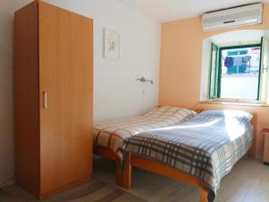 - une petite chambre avec 2 lits et une armoire dans l'établissement Apartments with WiFi Split - 13659, à Split