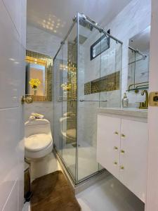 uma casa de banho com um WC e uma cabina de duche em vidro. em CASABOUTIQUE HOTEL em Salento