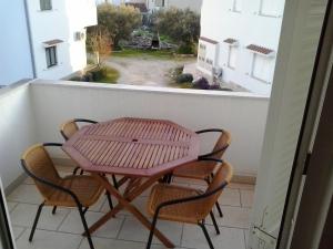 a table and chairs on a balcony with a window at Apartments with a parking space Rogoznica - 13684 in Rogoznica