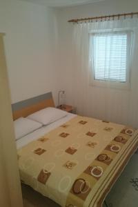 a bedroom with a bed and a window at Apartments with a parking space Rogoznica - 13684 in Rogoznica
