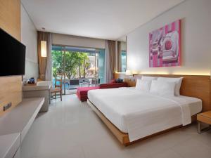 a bedroom with a large bed and a living room at The Kee Resort & Spa in Patong Beach