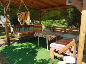 a picnic table and benches under a gazebo at Holiday House Krapets in Krapets