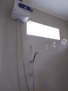 y baño con ducha y techo luminoso. en SHILA GUEST HOUSE, en Kelimutu