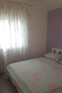a bedroom with a bed with a floral bedspread and a window at Apartments by the sea Stomorska, Solta - 13695 in Stomorska
