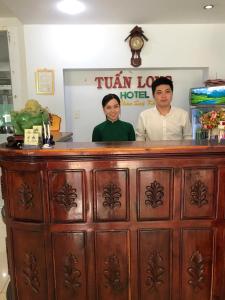 a man and a woman standing behind a bar at Tuan Long Hotel in Ho Chi Minh City