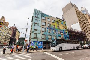 un bus est arrêté à une intersection dans une ville dans l'établissement JG Sohotel, à New York