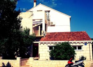 dom z motocyklem zaparkowanym przed nim w obiekcie Apartments by the sea Lumbarda, Korcula - 12839 w mieście Lumbarda