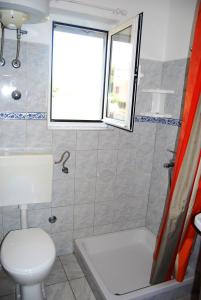 łazienka z toaletą, wanną i oknem w obiekcie Apartments by the sea Lumbarda, Korcula - 12839 w mieście Lumbarda +17 zdjęć