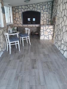 a room with a table and chairs and a stone wall at Secluded fisherman's cottage Cove Prnjica, Pag - 12620 in Kolan +10 photos