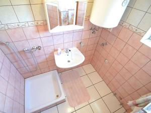 Baño alicatado de color rosa con lavabo y aseo en Apartments with parking space Povljana, Pag - 12169, en Povljana 24 fotos más