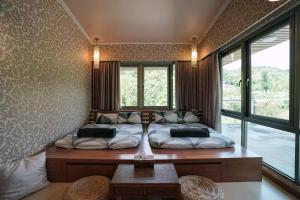 a bedroom with a bed and a table and windows at 小鳥敲門 Bird Villa in Shuangxi