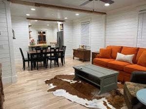 uma sala de estar com um sofá laranja e uma mesa em Walk to Bay Street and Historic Downtown Beaufort! Close to Parris Island MCRD!! em Beaufort