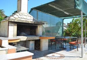 a outdoor pizza oven with a table and chairs at Studio Gradac 13681a in Gradac