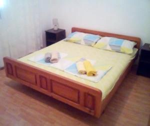 a bed with a wooden frame with slippers on it at Apartments with parking space Zavalatica, Korcula - 9690 in Zavalatica