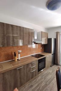 une cuisine avec des placards en bois et des appareils en acier inoxydable dans l'établissement Apartments with a parking space Zavalatica, Korcula - 9690, à Zavalatica
