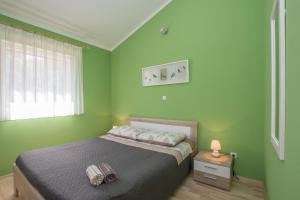 a bedroom with a bed with green walls and a window at Holiday house with a parking space Kastel, Central Istria - Sredisnja Istra - 14572 in Buje