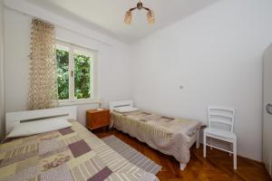 um quarto com uma cama, uma cadeira e uma janela em Apartments by the sea Kastel Stari, Kastela - 14577 em Kaštela