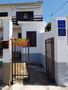 uma casa com um portão e algumas flores num cesto em Apartments with a parking space Senj - 14578 em Senj