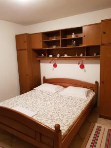 um quarto com uma cama e armários de madeira em Apartments with a parking space Senj - 14578 em Senj