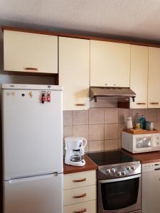 uma cozinha com armários brancos e um frigorífico branco em Apartments with a parking space Senj - 14578 em Senj